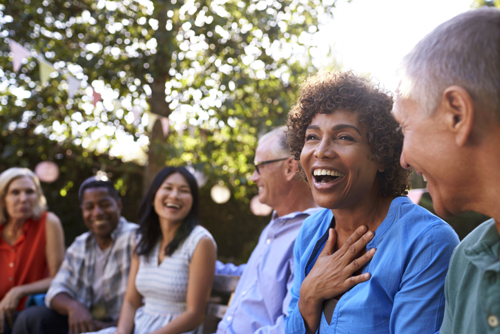 Group of friends laughing together during a private group psychic reading